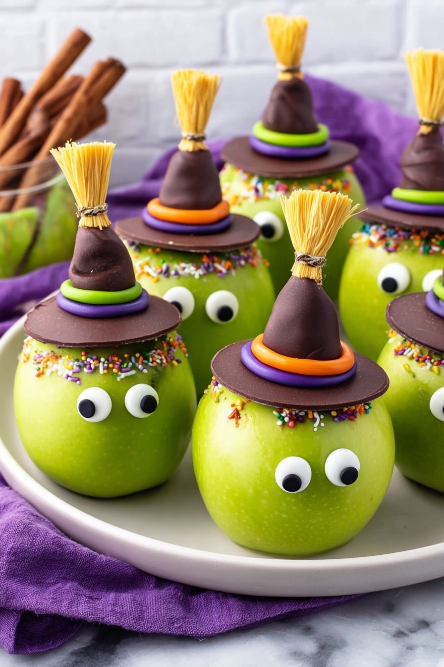 The image shows green apples decorated to look like little witches. Each apple has two round white candy eyes with black centers placed near the top front. On top of each apple is a hat made of chocolate shaped like a witch hat, decorated with colorful frosting rings in green, purple, or orange with small round and sprinkle decorations. Some apples hold a small broom made from light yellow strips tied with a twisted dark candy and a stick inserted into the top of the apple. The apples are all arranged on a white plate set on a white marbled surface with a purple cloth nearby. Photo taken with an iphone --ar 2:3 --v 7 - Halloween Witch Apples Apple Halloween Treat Spooky Halloween Snacks Halloween Party Ideas