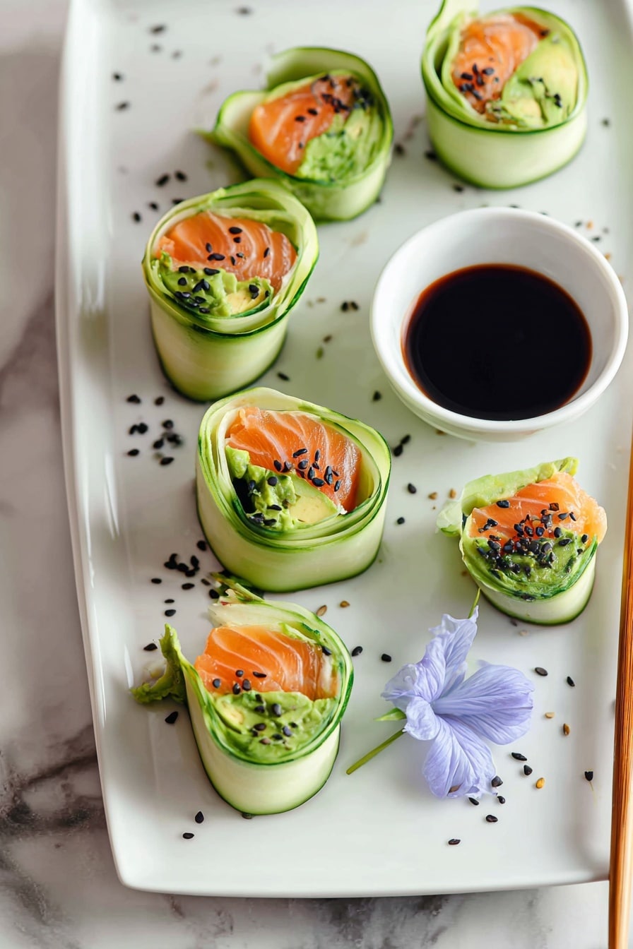 The image shows four sushi rolls wrapped in thin cucumber layers on a white rectangular plate, each roll filled with a bright green avocado layer and orange slices of salmon, topped with small black sesame seeds. The rolls are arranged in a line, with a small white cup of dark soy sauce near the top right side of the plate. Two light brown chopsticks rest on the right side of the plate, crossing near the cup. There is a single light purple edible flower next to the sushi rolls on the plate, all placed on a white marbled surface. Photo taken with an iphone --ar 2:3 --v 7 - Smoked Salmon Cucumber Roll with Avocado, smoked salmon appetizer, cucumber sushi roll, healthy seafood appetizer, easy salmon avocado bites