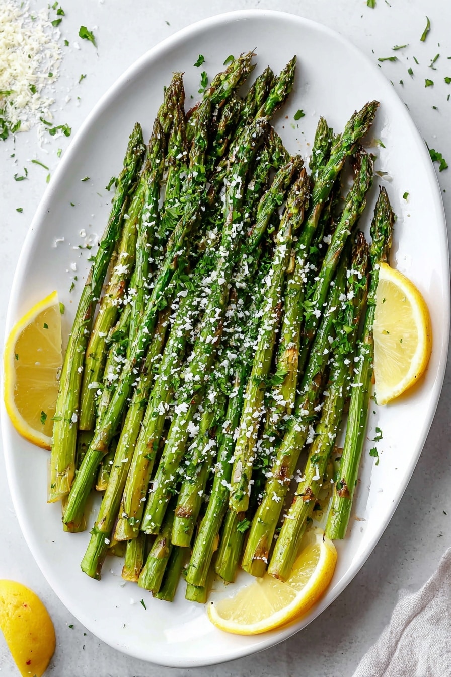 A white oval plate is filled with one layer of bright green roasted asparagus spears, arranged side by side with tips pointing towards the left. The asparagus has slight char marks and is sprinkled with small white grated cheese and green chopped herbs. Two lemon wedges are placed near the edges of the plate, one on the left and one on the bottom right. The plate sits on a white marbled surface with some scattered cheese and herbs nearby. Photo taken with an iphone --ar 2:3 --v 7 - Garlic Parmesan Roasted Asparagus with Lemon, roasted asparagus side dish, easy vegetable recipes, healthy asparagus ideas, lemon garlic asparagus