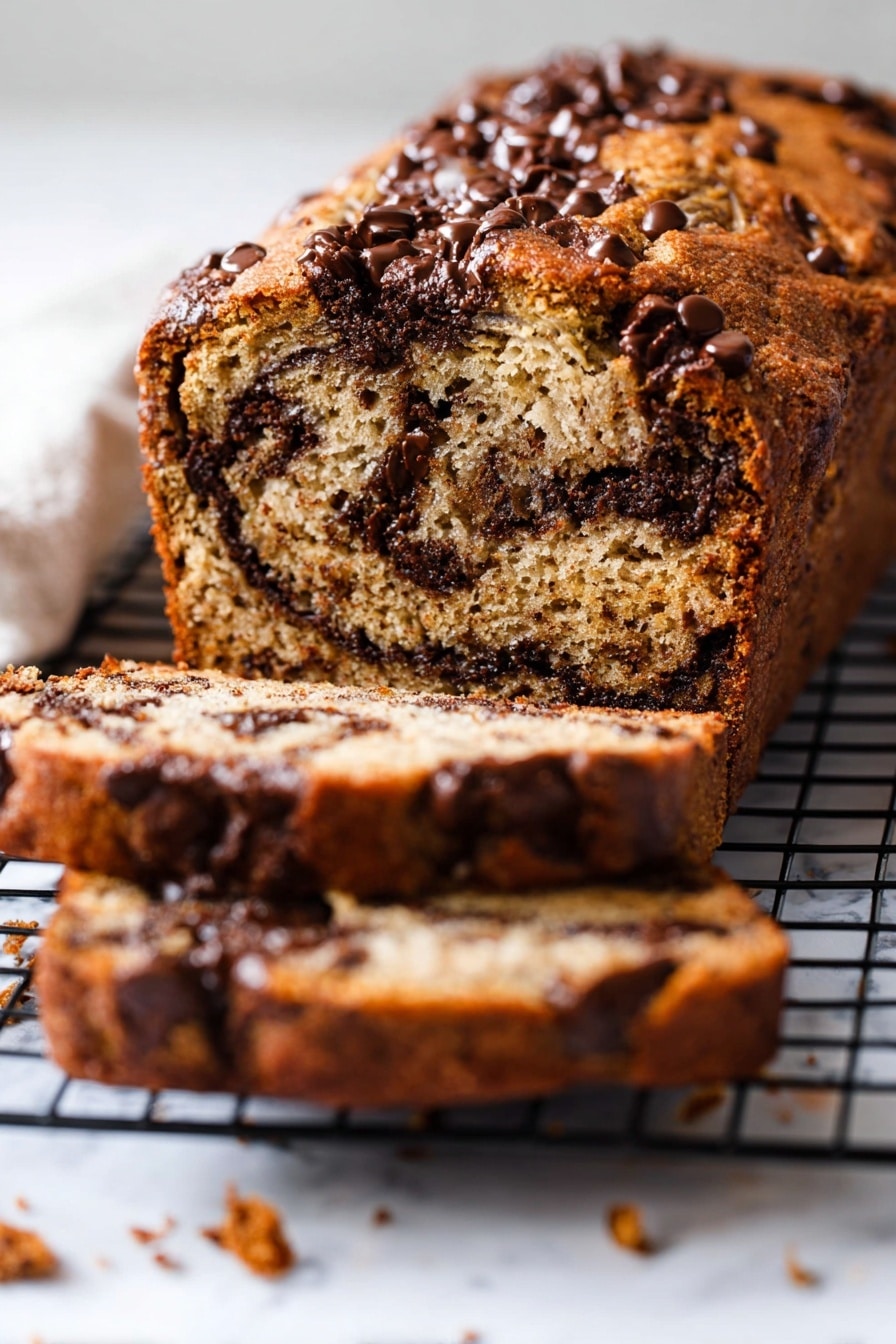 A close-up image of a sliced loaf of chocolate chip banana bread on a black cooling rack over a white marbled surface. The loaf has a golden-brown crust with dark melted chocolate chips scattered throughout the top and inside the bread. The inside texture looks moist with visible specks from the bananas and rich chocolate swirls crossing the layers. Two slices lie flat in front of the main loaf, showing the soft crumb and dense chocolate chip distribution. Small crumbs are scattered on the white marbled surface around the bread. Photo taken with an iphone --ar 2:3 --v 7 - Gluten-Free Banana Bread with Chocolate Chips, gluten-free banana bread recipe, healthy banana bread with chocolate, moist gluten-free banana loaf, easy gluten-free banana bread